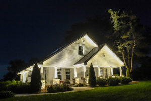 white double vaulted roofing landscape lighting tall trees aroud white siding